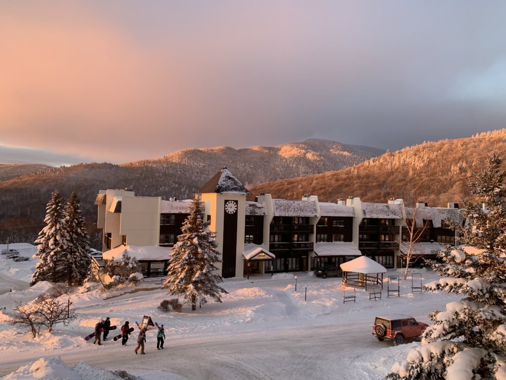 Some Skiers Walking Through The Main Base Village On Their Way To Night Skiing During Sunset