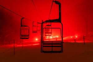 Torchlight Parade of Red Lights Marches Down the Slopes with Mid Mountain Chair in the Foreground