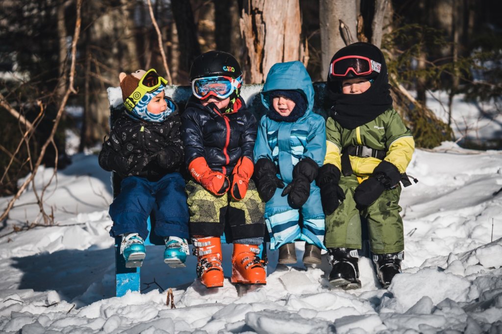 A Few Toddlers Sitting By The Ski Slope