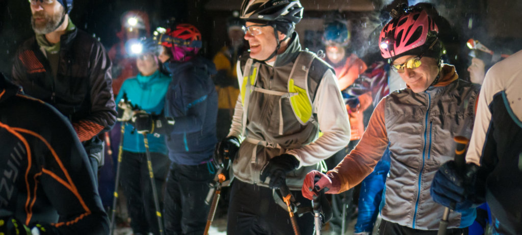 Skiers with headlamps prepare to race