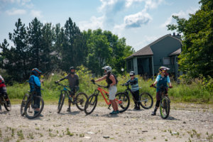 Women gather on their mountain bikes on a dirt patch