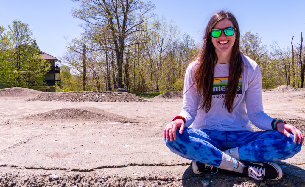 Woman sits cross-legged in the Progression Park facing forward