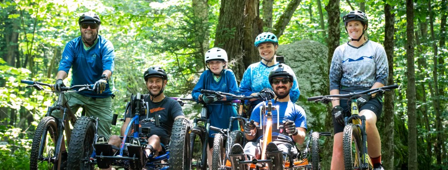 A group of Vermont Adaptive mountain biking instructors and participants pose for a photo on their bikes