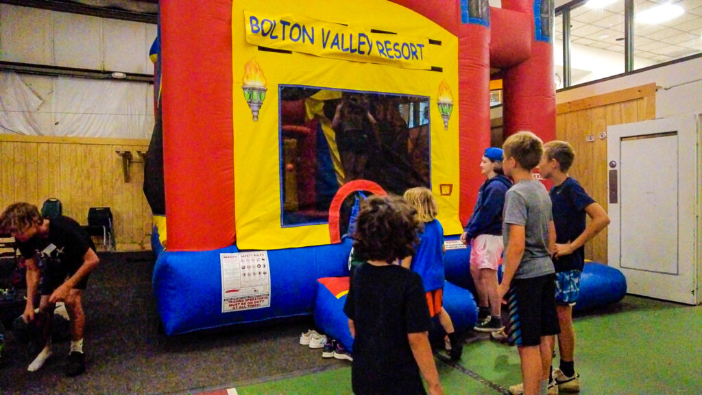 Children gather outside a bouncy house waiting to enter