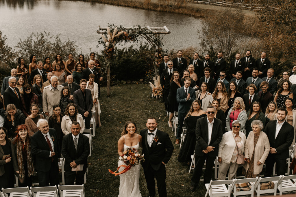 The Ponds exterior with a bride, groom, and guests posing for a photo